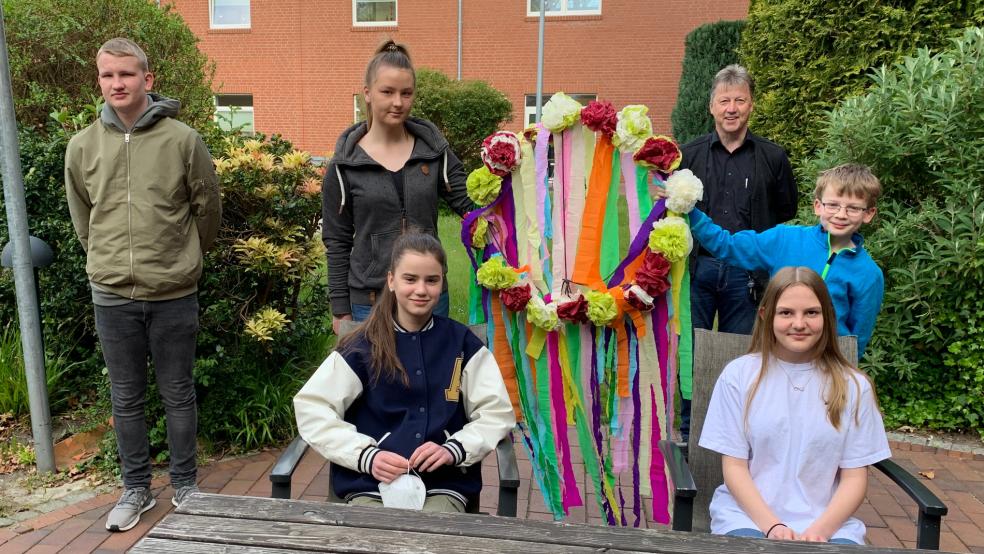 Nach zwei Jahren Pandemie-Pause begrüßte das Altenzentrum Rheiderland in Weener wieder Schüler zum Zukunftstag. Sie konnten in die Arbeitsbereiche Pflege, Betreuung und Haustechnik »schnuppern« und durften mit den Bewohnern einen Maibaum binden und schmücken. Von links: Elias Schaa, Tomke Franzen, , Heimleiter Andreas Cramer, Lennart Sap. Vorne: Elma Hadzic und Laura Boekhoff. © privat