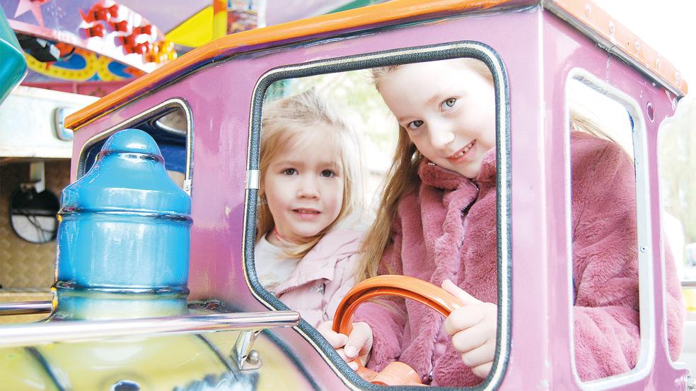 Ella (links) und ihre Schwester Lina, beide kommen aus Weener, gehörten zu den ersten Kindern, die gestern mit dem Kinderkarussell an der Marktstraße eine Runde drehten. Die Marktbuden und Fahrgeschäfte öffneten am frühen Nachmittag.  © Foto: Hoegen