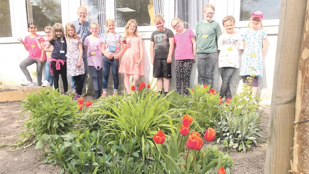 Die Schüler der Garten-AG posieren mit AG-Leiter Folkert Kruse vor ihrem Garten auf dem Schulgelände.  © Foto: Busemann