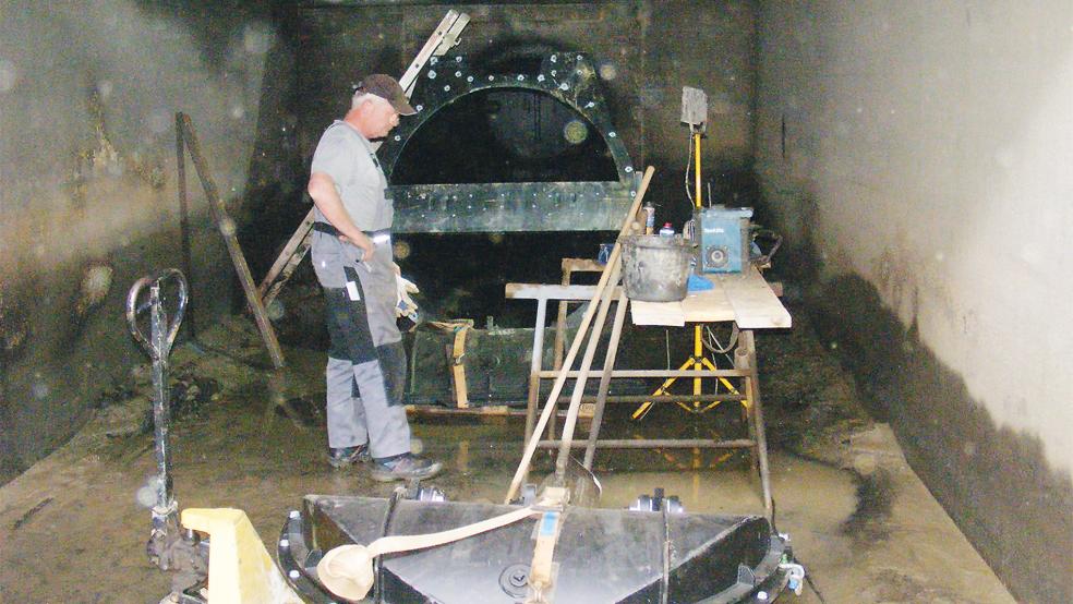 Wo sonst immer Wasser steht: Sielacht-Mitarbeiter Jens Meinders im trockengelegten Bereich vor einem der drei Auslaufrohre des Schöpfwerks in Soltborg. Die neuen Klappen, die zurzeit eingebaut werden, öffnen sich bei der Entwässerung des Sieltiefs in die Ems und schließen sich wieder, damit das Wasser nicht zurücklaufen kann.  © Foto: Szyska