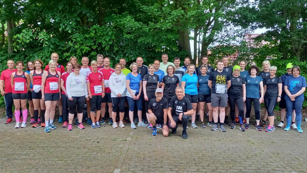 Richard Hartema (kniend rechts) organisiert die Busfahrten der Rheiderländer Ossilooper. Von der Busgemeinschaft hat er zur 100. Etappe sein T-Shirt geschenkt bekommen.  © Foto: Born