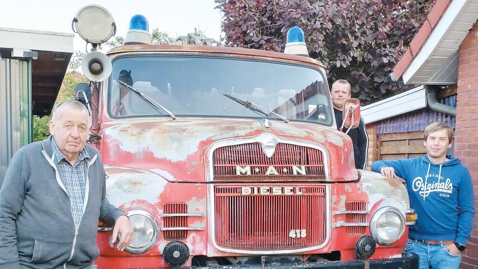 Heinrich Akkermann (links) und seine Söhne Timo (vorne rechts) und Ingo vor dem Feuerwehr-Oldtimer. © Foto: privat
