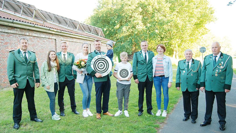 Das neue Königshaus: Von links Vorsitzender Andreas Groen, Martje und Arno Broers, das Königspaar Sonja und Martin Wilkens, der neue Schützenkönig hält seinen elf Monate alten Sohn Jonas auf dem Arm, Jungschützenkönig Bente Sterrenberg, Matthias und Antje Meyer, Jan-Dieter Janssen und Jugendtrainer Erich Schröder.  © Foto: Hoegen