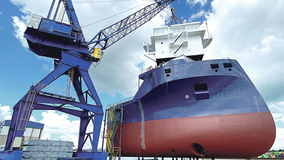 Nachdem das Vorderschiff eines neuen Mehrzweckfrachters aus der Halle der Ferus Smit Werft geholt wurde, hievte ein Kran heute Nachmittag das Ruderhaus hinauf. Es handelt sich um den ersten von zwei jeweils 144 Meter langen und 18 Meter breiten Neubauten.  © Foto: Stadtwerke Leer