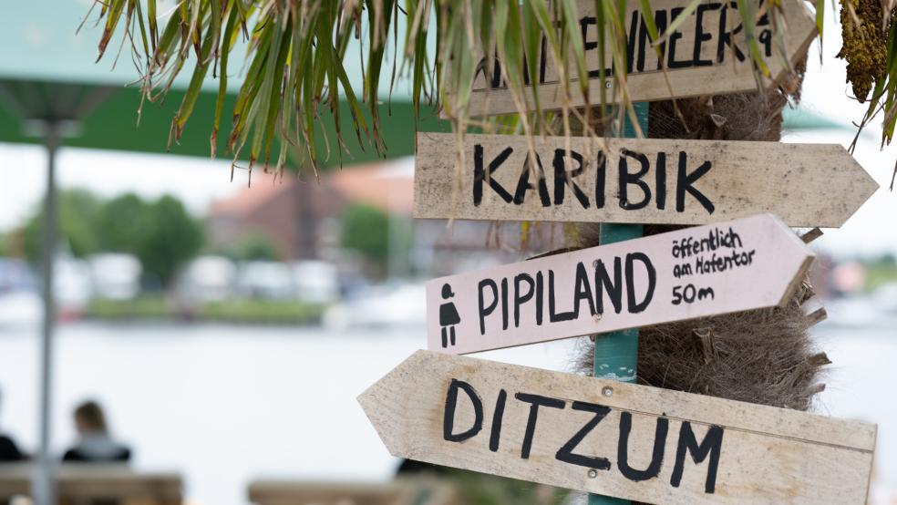 Ein unterhaltsamer Wegweiser an der Strandbar am Delft in Emden. Die Tourismusbetriebe an der Nordseeküste stellen sich zum ersten großen Sommerwochenende in Niedersachsen auf einen Schwung von Tagesurlaubern ein. © Klemmer (dpa)