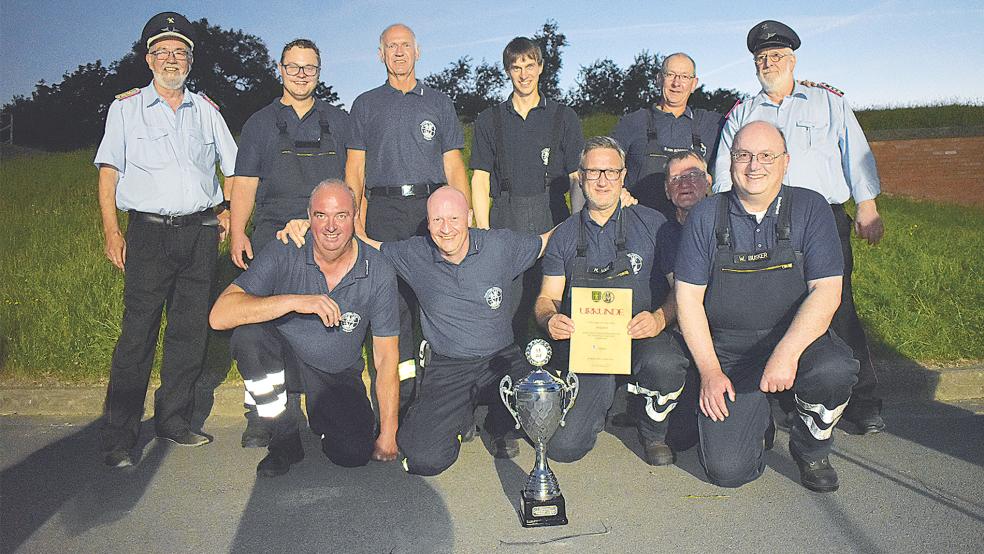 Mit 436,37 von 500 Punkten gewann die Feuerwehr Holtgaste mit Gruppenleiter Wolfgang Busker (vorne rechts) zum dritten Mal in Folge den vom Jemgumer Ehrengemeindebrandmeister Friedrich Schmidt (oben links) gestifteten Wanderpokal.  © Foto: Kuper