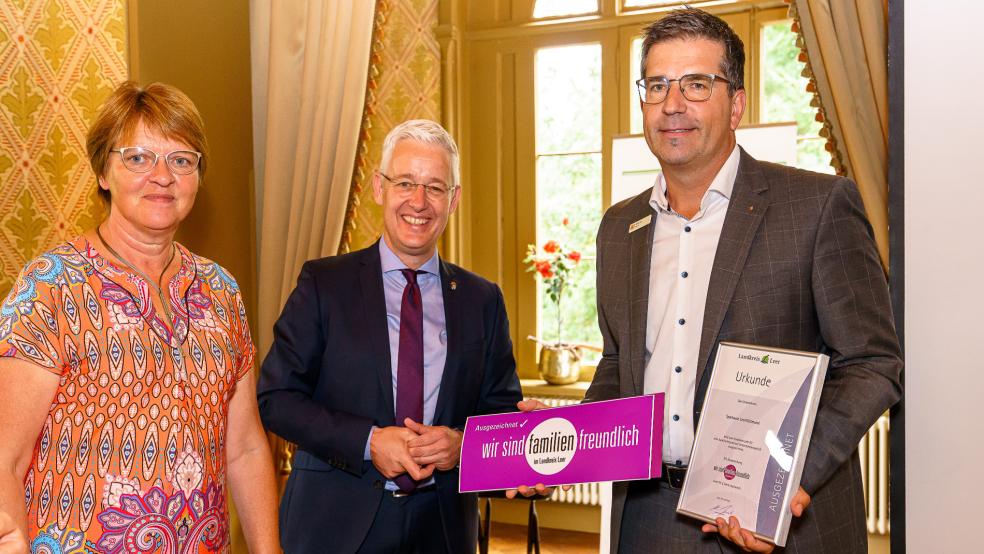Meta Janssen-Kucz, Vorsitzende des Ausschusses für Gleichstellung, Familienförderung und Migration, und Landrat Matthias Groote überreichen die Auszeichnung an Andraes Fahle, Bereichsleiter Personal der Sparkasse LeerWittmund. © Landkreis Leer