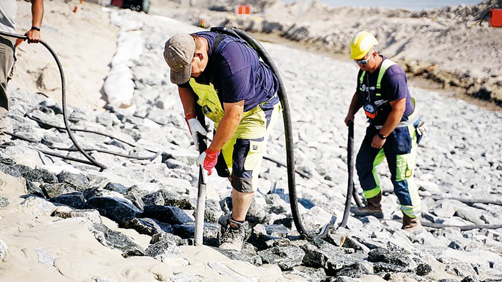 Die Schüttsteine unterhalb und oberhalb der Asphaltberme am Westdeich werden mit Spezialmörtel vergossen und so zusätzlich gegen die starke Beanspruchung durch Wellen gesichert.  © Foto: NLWKN