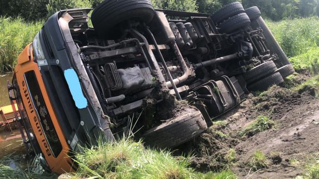Lkw kippt um und rutscht in Kanal