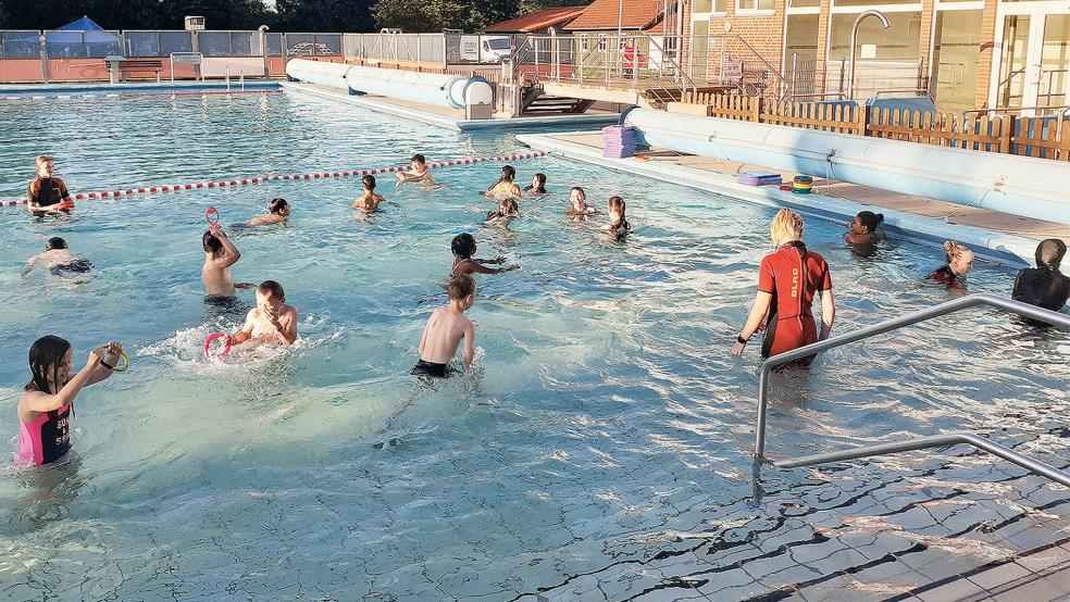 Tauchringe, Schwimmnudeln und Übungen am Beckenrand: Alina Pastoor sowie Lena und Lisa Buntjer bringen in den Sommerferien rund 20 Geflüchteten das Schwimmen bei.  © Foto: Berents