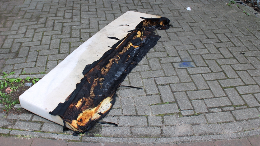Anwohner zogen die brennende Matratze vom Gebäude weg. © Foto: Rand (Feuerwehr)