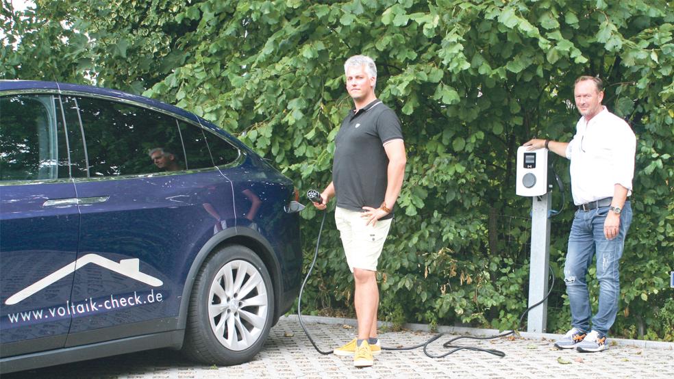 Auf dem Firmengelände von Proengeno in Nendorp steht jetzt eine E-Ladesäule. Voltaik-Check-Geschäftsführer Marco Jürgens (links) lädt die Batterie seines Tesla-Elektroautos in Gegenwart von Proengeno-Geschäftsführer Gerold Hagena.  © Foto: privat