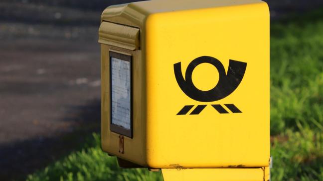 Mann steckt mit Hand in Briefkasten fest