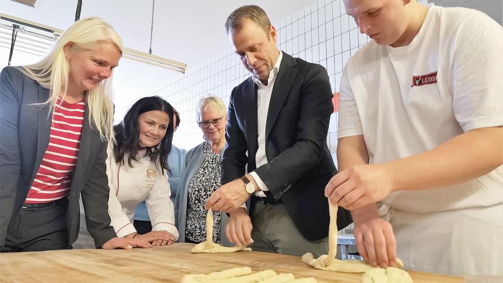 Jasper Lübbers (rechts) zeigte CDU Generalsekretär Mario Czaja (Zweiter von rechts), wie man einen Hefezopf herstellt. Gespannt schauen die CDU-Landtagskandidatin Silke Kuhlemann, die CDU-Bundestagsabgeordnete Gitta Connemann und die Vorsitzende des CDU-Stadtverbandes Weener, Hildegard Hinderks, dabei zu (von links).  © Foto: privat