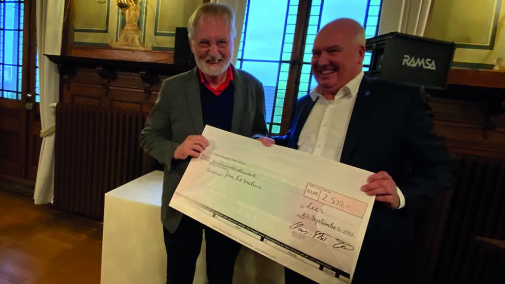 Bürgermeister Claus-Peter Horst (rechts) überreichte den symbolischen Scheck an Jan Cornelius. © Stadt Leer