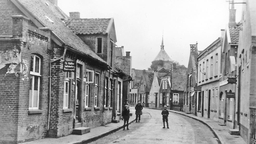 Eine historische Aufnahme der Süderstraße in Weener zeigt auf der linken Seite die Häuser von Auktionator Theodor Mülder, Klempner Theodor Bruns, Uhrmacher R. Jung, Kurzwaren Bertha Goldsmid, Buchdrucker E. Remmers und Stellmacher S. Spree. Vor den Häusern mit den Nummern 27, 44 und 57 sollen »Stolpersteine« an die dort ehemals wohnenden jüdischen Familien Arnold Israels, Josef Arons und Lazarus Löwenstein erinnern.  © Foto: Sammlung Kramer (sowasdat.rheiderland.de)