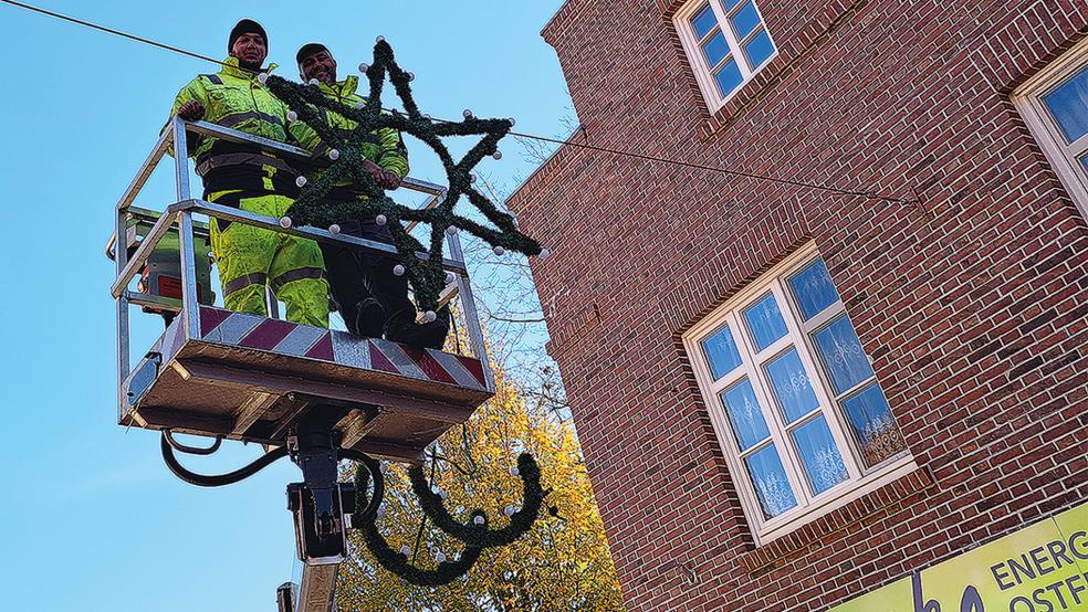 Mitarbeiter der Firma Elektro Kruse aus Leer hängten am Samstag insgesamt 28 Überspannungen mit der Weihnachtsbeleuchtung in der Innenstadt von Weener auf.  © Foto: Szyska