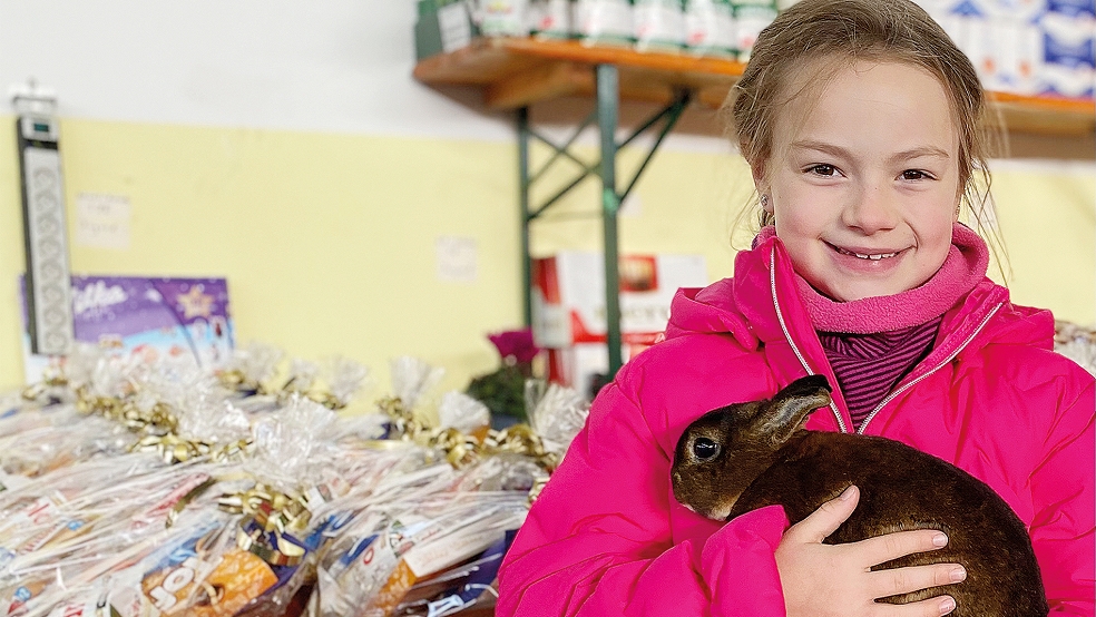 Zu den ostfriesischen Jungzüchtern gehört die siebenjährige Maya Goemann - hier mit einer castorfarbigen Zwerg Rexe auf dem Arm.  © Foto: Kuper
