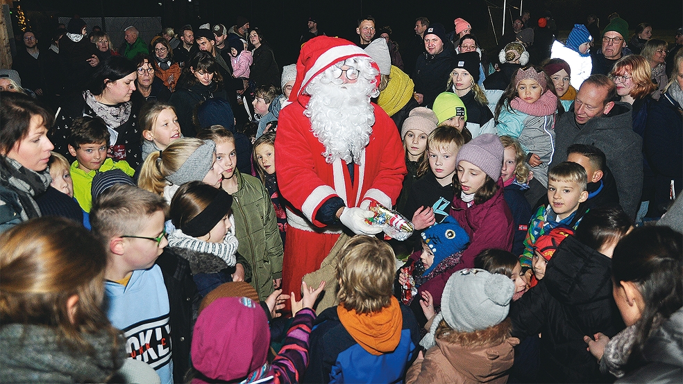 Wegen des großen Andrangs verteilte der Weihnachtsmann seine kleinen Präsente an die Kinder unter Flutlicht auf dem Sportplatz. © Foto: Wolters