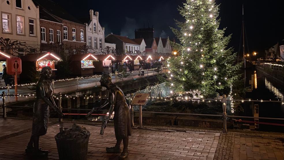 Dieses Bild kann nicht jeder Adventsmarkt bieten: Im Beisein der »Törfwieven«, mit einem schwimmenden Weihnachtsbaum auf einem Ponton und mit festlich beleuchteten Holzhäuschen vor der Kulisse der historischen Wohnhäuser zeigte sich der Alte Hafen in Weener am Wochenende von seiner besten Seite. © Kuper