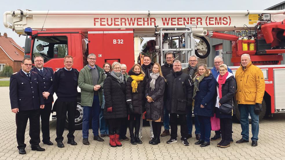 Gäste und Gastgeber vor dem Feuerwehrhaus in Weener, im Hintergrund die Hubrettungsbühne.  © Foto: Kuper