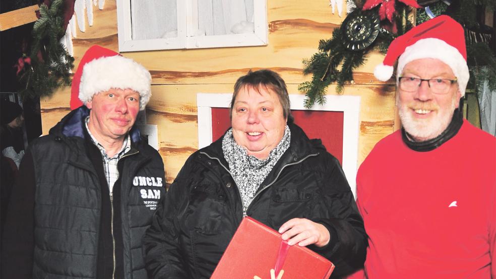 Friedrich Reich (links) und Curt Weber von der Heimatbühne übergaben einen symbolischen Karton an Sieglinde Robbe.  © Foto: Wolters 