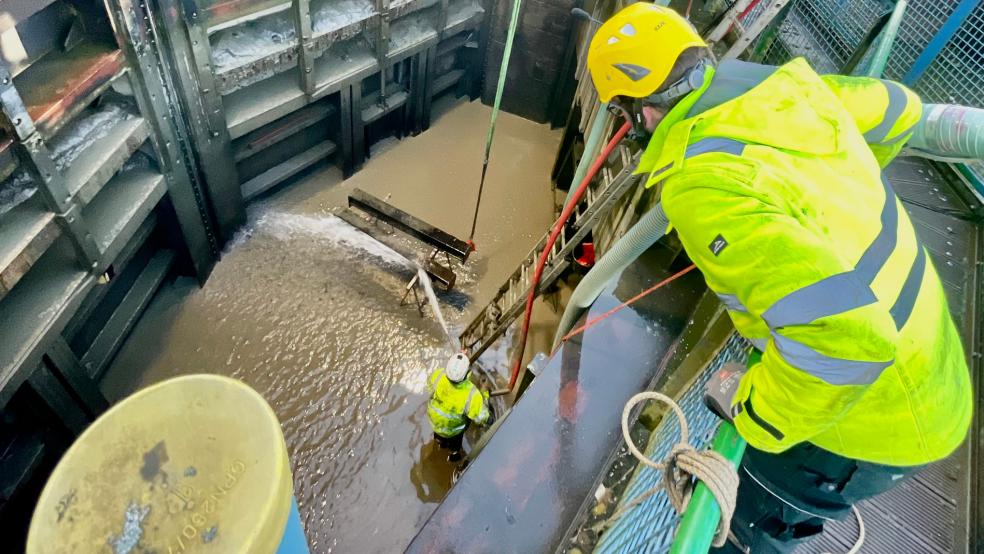 Mitarbeiter der Firma Graupe und der Hafen und Tourismus GmbH erneuern die Rollschützdichtungen der Schleuse in Weener.  © Foto: Stadt Weener
