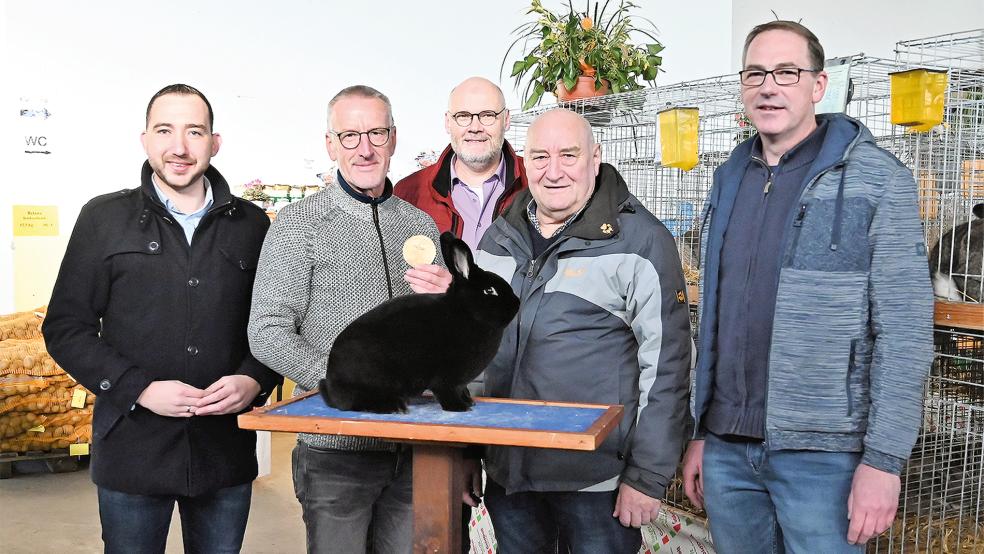 Bei der Eröffnung der 60. Kreisverbandsschau: (von links) Nico Bloem, SPD-Landtagsabgeordneter, Preisträger Hermann Nagel mit seinem Schwarzen Wiener, , Rüdiger Frers, Stellvertretender Kreisverbandsvorsitzender, Focko Stöhr, Kreisverbandsvorsitzender, und Ausstellungsleiter Michael Goemann vom gastgebenden Verein I 57.  © Foto: Penning