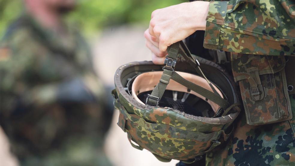 Ein Bundeswehr-Reservist in Ausbildung hält während eines Ausbildungsmoduls seinen Helm in der Hand.  © Foto: dpa