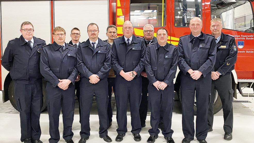 Umrahmt von Ortsbrandmeister Hans-Hermann Leemhuis (links) und Abschnittsleiter Ernst Berends (rechts) zeigt das Foto (von links) als Beförderte Karl-Heinz Jürgens und Frank Volkhusen (Hauptfeuerwehrmann), Marco Koenen (Löschmeister) und Ralf Leemhuis (Oberlöschmeister) sowie den geehrten Johannes Auerbach (25-jähriges Dienstjubiläum), in der Reihe dahinter (von links) Dennis Iwanoff (stellvertretender Ortsbrandmeister), Bürgermeister Uwe Sap und Gemeindebrandmeister Ingfried Battermann.  © Foto: Kuper