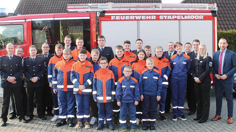 Auf der Hauptversammlung: (von links) Jugendfeuerwehrwart Ronald Drewes (Feuerwehr Diele), Kreisjugendfeuerwehrwart Günter Haase, stellvertretender Ortsbrandmeister Matthias Müller (Feuerwehr Diele), Stadtbrandmeister Jörg Fisser, stellvertretender Jugendfeuerwehrwart Arno Bröring (Feuerwehr Diele) sowie (von rechts) stellvertretender Bürgermeister Nico Bloem. stellvertretende Stadtjugendfeuerwehrwartin Jannette Reinders, Jugendfeuerwehrwart Dennis Modder (Feuerwehr Stapelmoor), stellvertretender Jugendfeuerwehrwart Lars Berger (Feuerwehr Stapelmoor), stellvertretender Ortsbrandmeister Siegfried Buttjes (Feuerwehr Stapelmoor) und Ortsbrandmeister Klaas-Enno Haken (Feuerwehr Vellage) mit dem Feuerwehr-Nachwuchs.  © Foto: Rand (Feuerwehr)