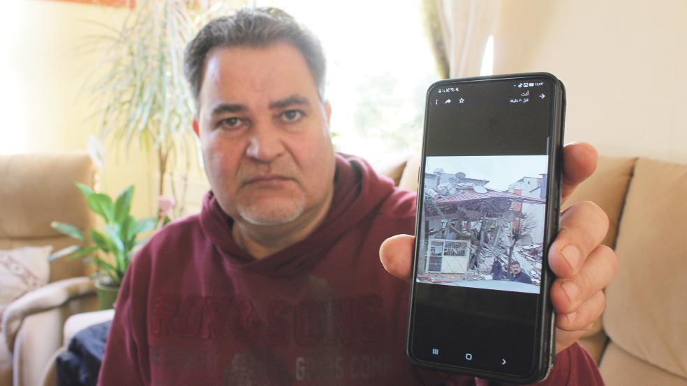 Malek Hurkus zeigt ein Bild eines ehemaligen Geschäfts in der Türkei, das einem Freund von ihm gehörte. Durch die schweren Erdbeben liegt es komplett in Trümmern, eine Frau wurde darunter begraben.  © Foto: Busemann