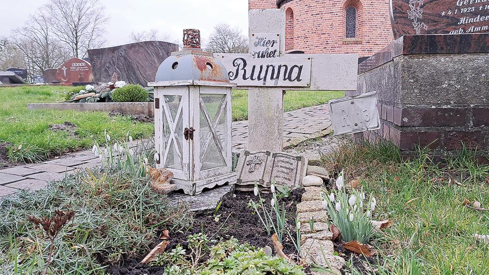 Ein Holzkreuz, einige Dekorationen und ein Windlicht: Bis heute kümmern sich Mitglieder der Kirchengemeinde in Bingum um die Pflege der letzten Ruhestätte von Marie Trouper, die 1894 am Rande eines Gräberfeldes beim östlichen Ausgang des Friedhofs bestattet wurde.  © Foto: Szyska