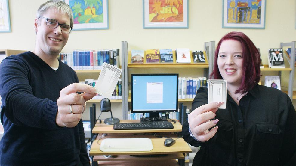 Mit Transpondern, die Bürgermeister Heiko Abbas und Bibliotheks-Leiterin Sarah Möhlmann hier präsentieren, werden die Daten der Medien zukünftig erfasst. Dadurch können auch mehrere Exemplare zeitgleich verbucht und gesichert werden.  © Foto: Busemann