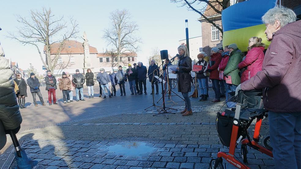 Keine guten Nachrichten für die rund 70 Teilnehmer der Mahnwache für den Frieden auf dem Denkmalplatz in Leer hatte Mechthild Tammena (am Mikrofon): Der Krieg in der Ukraine wird immer heftiger.  © Foto: Kellner