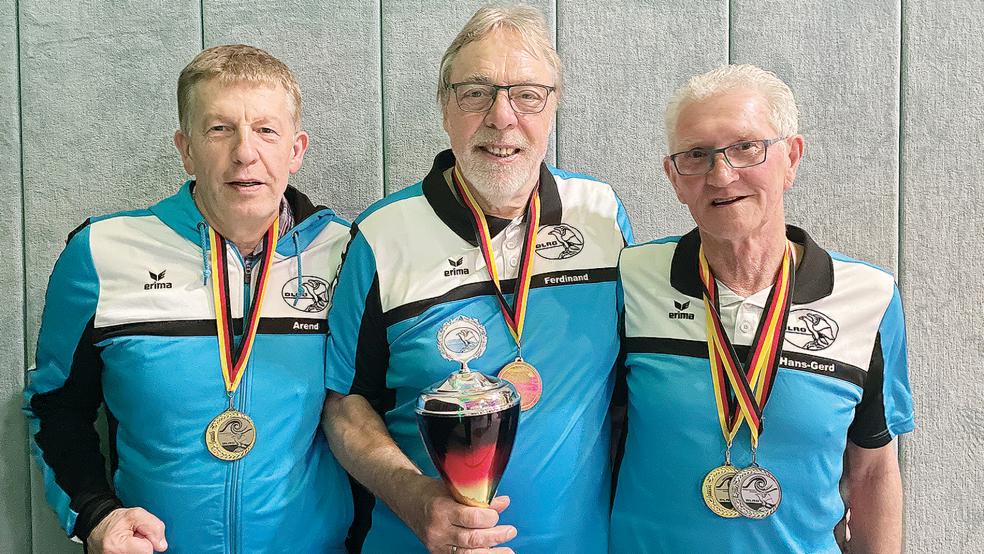 Goldmedaillen und Siegerpokal: Die männliche AK 280+ um Arend Duis (von links), Ferdinand Reit und Hans-Gerd Hülsmann ist eins der beiden Teams aus Weener, die Deutscher Meister geworden sind. Auf dem Foto fehlt Gerhard Lindt.  © Foto: privat