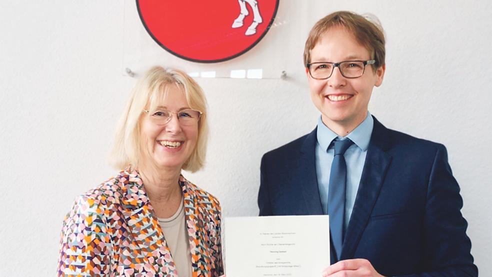 Frauke Seewald, Präsidentin des Landgerichts, überreicht dem neuen Direktor des Amtsgerichts Emden, Henning Deeken, die Ernennungsurkunde.  © Foto: privat
