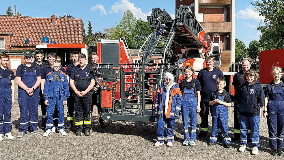 Die Mitglieder der Jugendfeuerwehr Weener und ihre Betreuer machten nach ihrem Besuch ein gemeinsames Erinnerungsfoto vor der Drehleiter 23/12 der Berufsfeuerwehr in Emden.  © Foto: privat