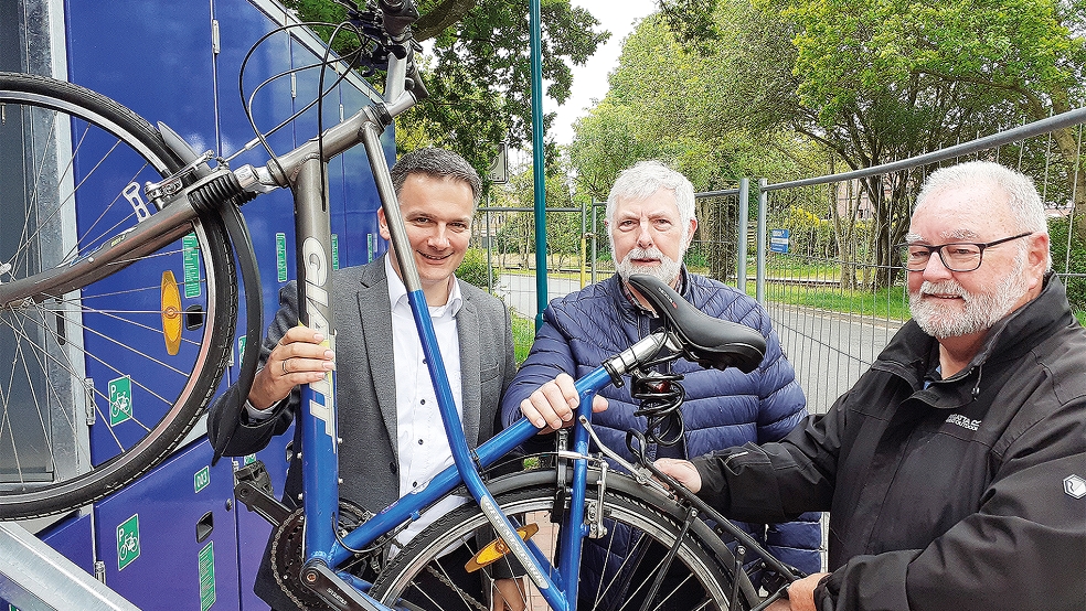 Bürgermeister Uwe Sap (von links), Georg Huisinga, Vorsitzender des Ausschusses für Bauleitplanung, Straßen Wege und Umwelt, sowie Ortsvorsteher Karl-Georg Volkhusen freuen sich über die neuen Fahrradboxen in Bunde.  © Foto: Berents