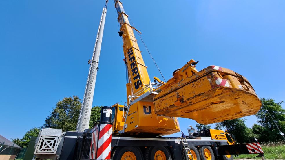Mit Hilfe eines Schwerlastkrans der Firma Ulferts aus Neermoor errichteten schwindelfreie Arbeiter gestern an der Bundesstraße 436 im Einmündungsbereich zum Gewerbegebiet an der Industriestraße in Weener einen Funkmast für die EWE Netz GmbH. © Szyska