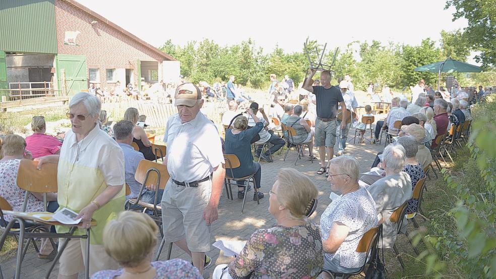 Die Gäste des Gottesdienstes suchten bei hochsommerlichem Wetter Plätze im Schatten von Bäumen.  © Wolters