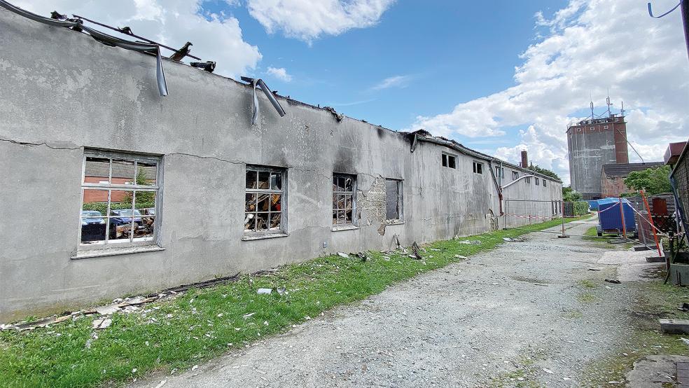 Ein Weg trennt die Brandruine (links) von den Häusern der Straße »Am Hafen links«. Vor dem Gebäude sind Schuttteile zu sehen, wie sie auch in angrenzenden Gärten von Anliegern zu finden sind.  © Foto: Hanken