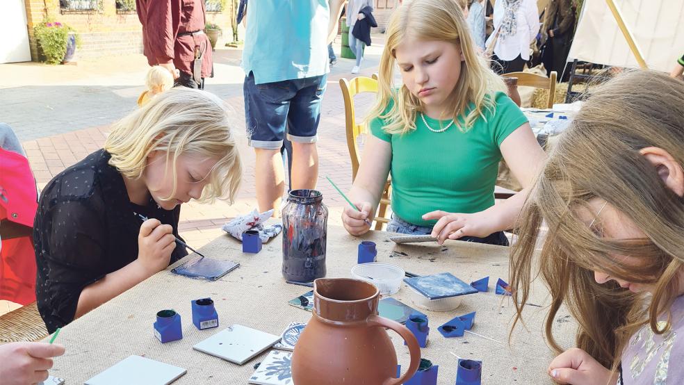 Kinder beim Bemalen von Fliesen.  © Foto: Akkermann