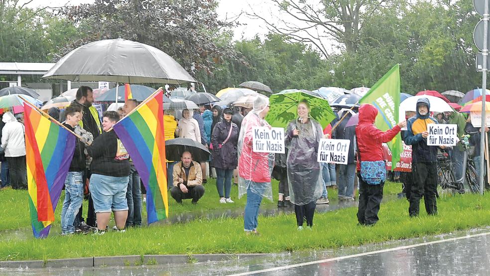 Der Dauerregen konnte den Demonstranten nichts anhaben. Tapfer hielten sie ihre Regenbogenfahnen und Schilder an der Zufahrtsstraße zum Veranstaltungsgelände hoch.  © Foto: Hüsing
