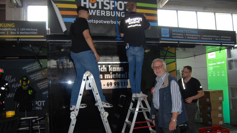 Auf dem Stand der Firma »Hotspot Werbung« aus Westoverledingen liefen heute Vormittag noch die Aufbauarbeiten. Von links: Arda Achmetoglou, Leon Lucas Ibelings, Werbegemeinschafts-Vorsitzender Evert Pastoor und Georg Vennenga. © Hoegen