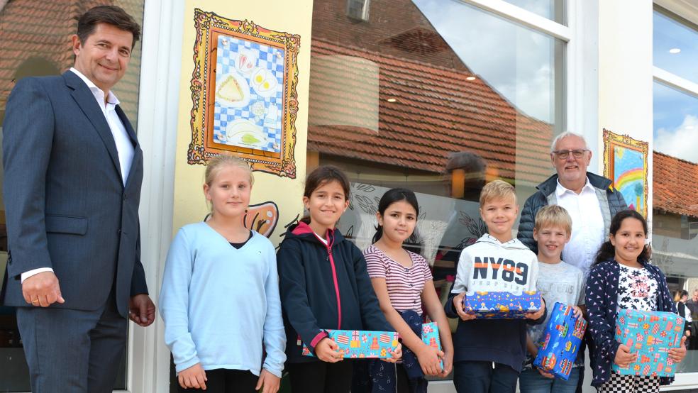 Der Geschäftsführer des J. Bünting Teehandelshauses, Heiko Lochner, und der stellvertretende Bürgermeister Bruno Schachner mit den Gewinnerkindern.  © Foto: Unternehmensgruppe Bünting