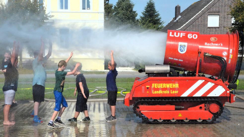 Bei hochsommerlichen Temperaturen um 30 Grad Celsius kühlte das feine Sprühwasser aus dem Löschroboter LUF 60 der Feuerwehr Jemgum vorrangig den Feuerwehr-Nachwuchs ab. © Ammermann