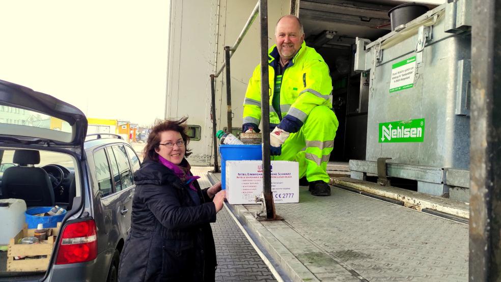 Mobile Schadstoffsammlung: Heike Barth aus Moormerland nutzt den Service und gibt bei Heiko Janssen, Mitarbeiter der Firma Nehlsen, alte Sachen ab.  © Landkreis Leer