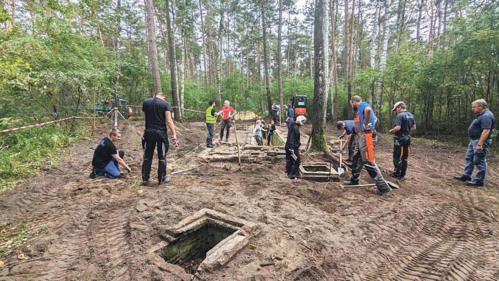 Unter Anleitung von NLWKN-Ausbildern und Mitarbeiterinnen und Mitarbeitern der Gedenkstätte Bergen-Belsen richten die Auszubildenden des Landesbetriebs Fundamente einer Latrinenanlage her.  © Foto: Lina Krüger