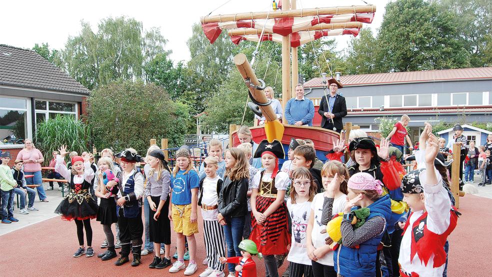Ein großer bunt kostümierter Piratenchor eröffnete das Fest. Im Hintergrund an Deck des Piratenschiffes Schulleiterin Antje Onnen-Wessels, Bastian Förster (Stiftung Kinderförderung von Playmobil) und Bürgermeister Heiko Abbas (von links).  © Hoegen